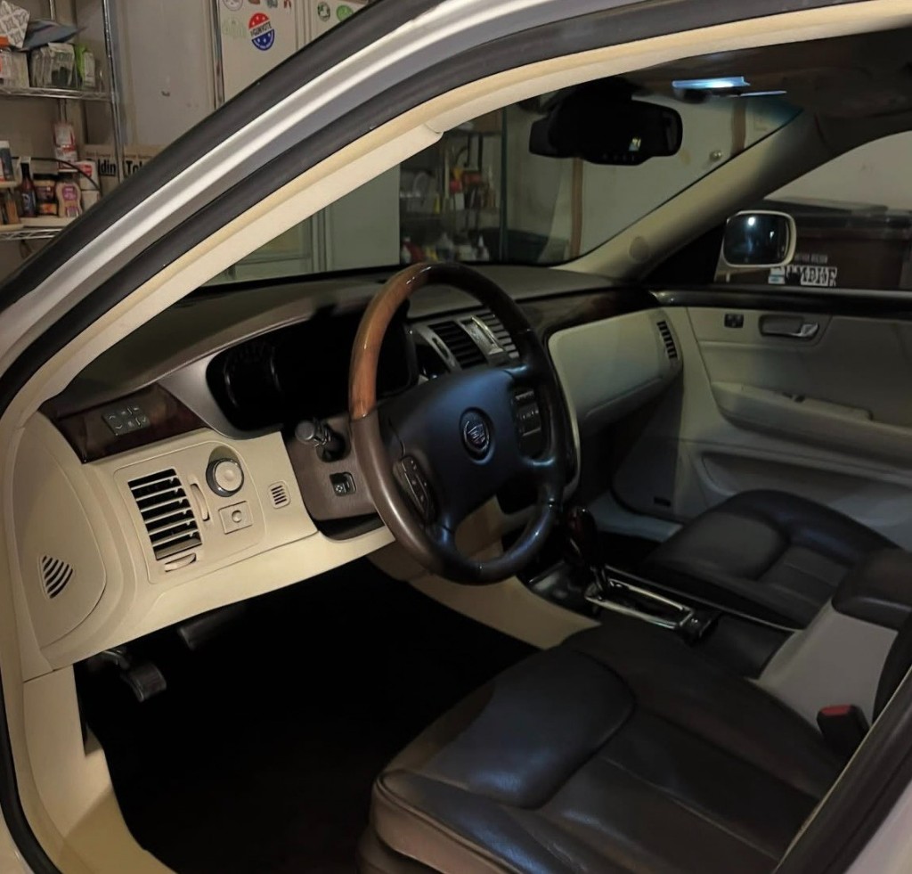 Professionally detailed vehicle interior with two-tone leather, wood trim on the steering wheel, and a spotless dashboard