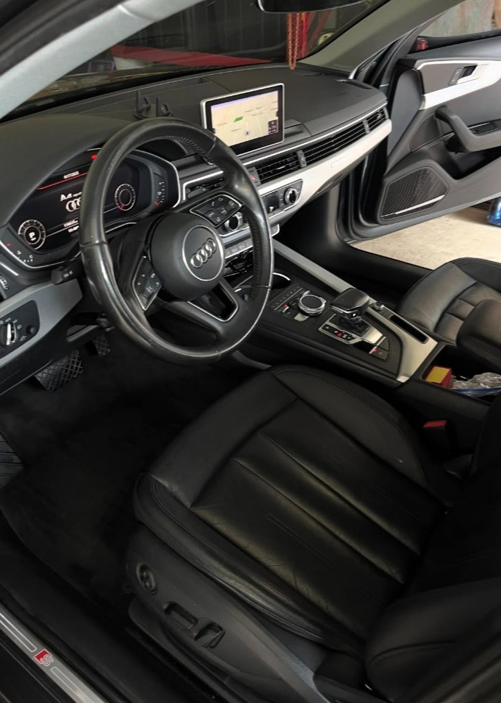 Detailed modern car interior with black leather seats, digital displays, and spotless center console